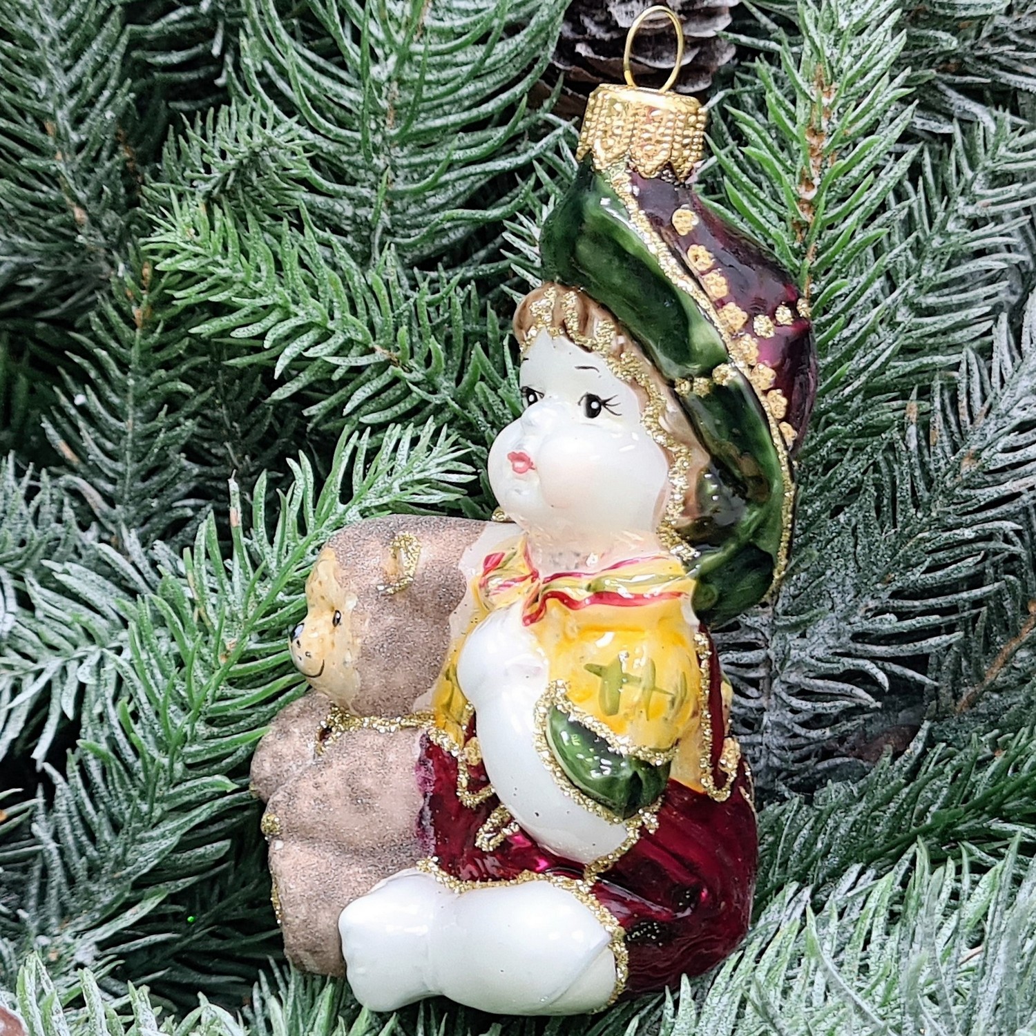 фото Стеклянная елочная игрушка Девочка с мишкой сидит