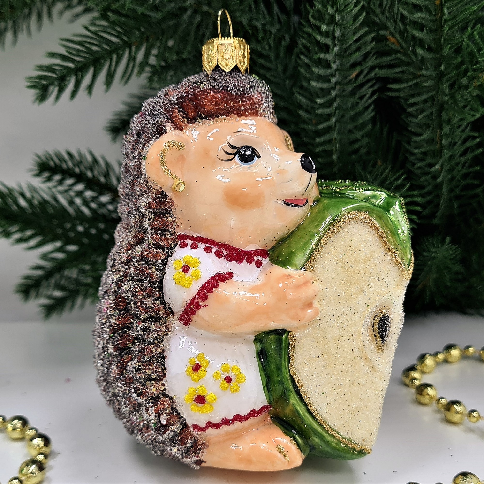 фото Стеклянная елочная игрушка Ежик с яблоком девочка