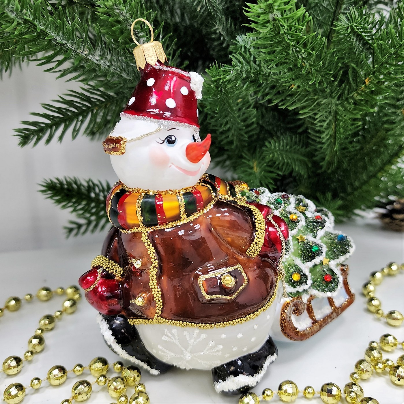 фото Стеклянная елочная игрушка Снеговик тянет саночки