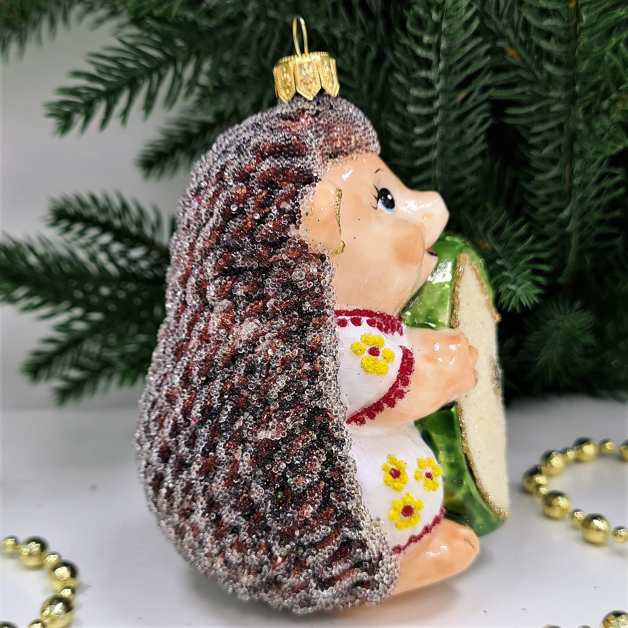 фото Стеклянная елочная игрушка Ежик с яблоком девочка