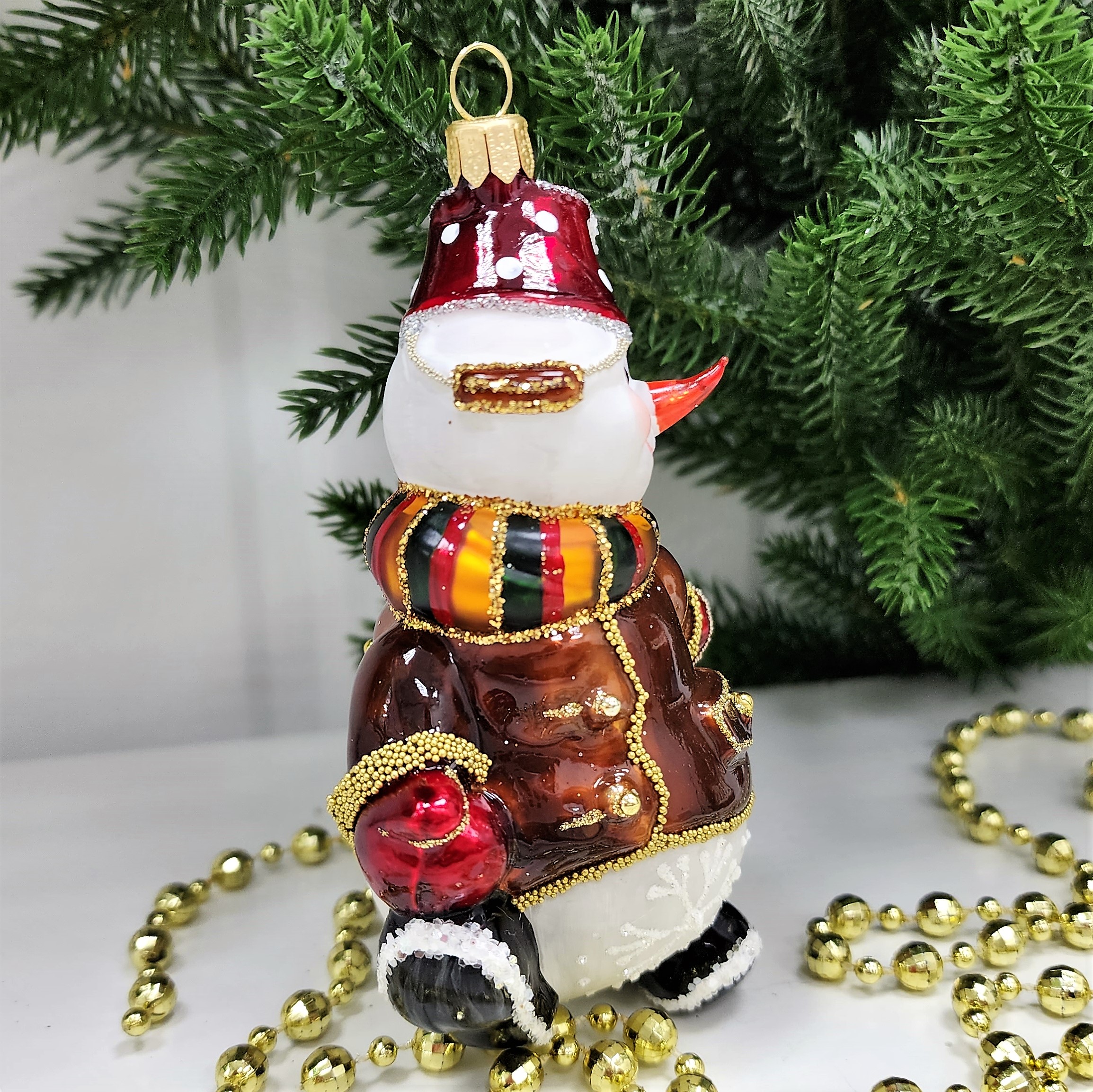 фото Стеклянная елочная игрушка Снеговик тянет саночки