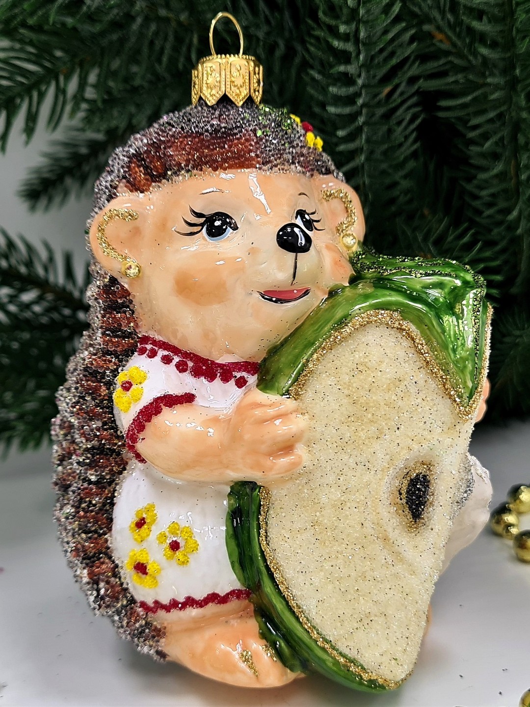 фото Стеклянная елочная игрушка Ежик с яблоком девочка