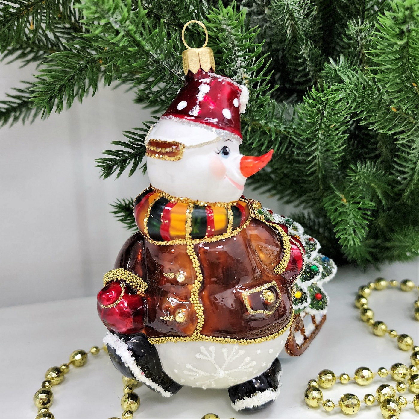 фото Стеклянная елочная игрушка Снеговик тянет саночки